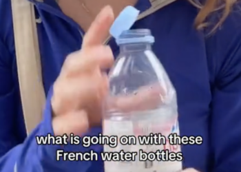 woman holding a tethered water bottle with writing over it